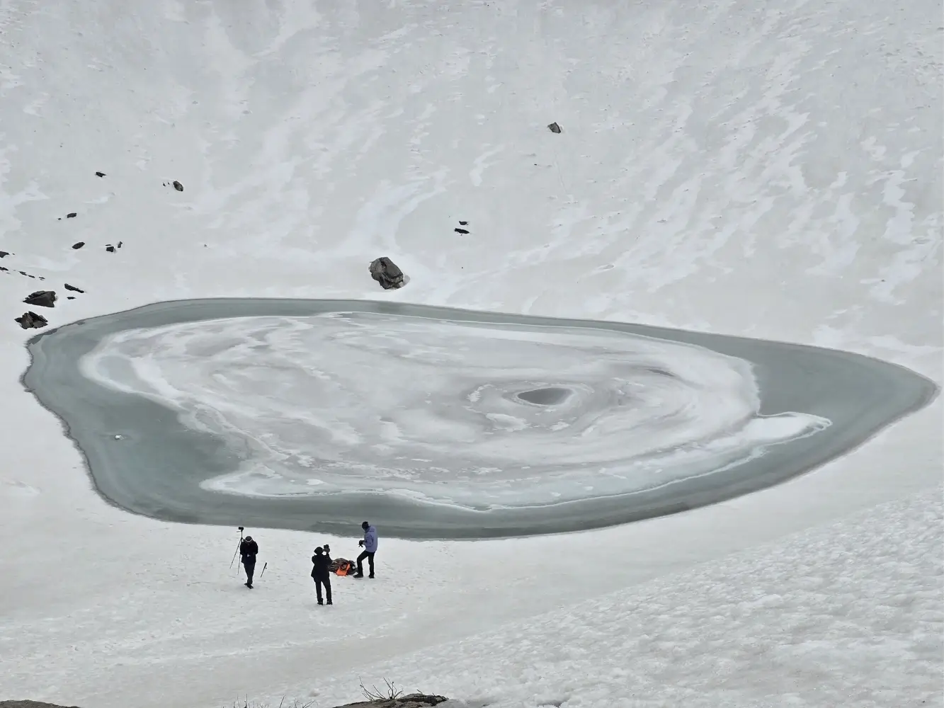 Frozen Roopkund Lake surrounded by snow in Uttarakhand
