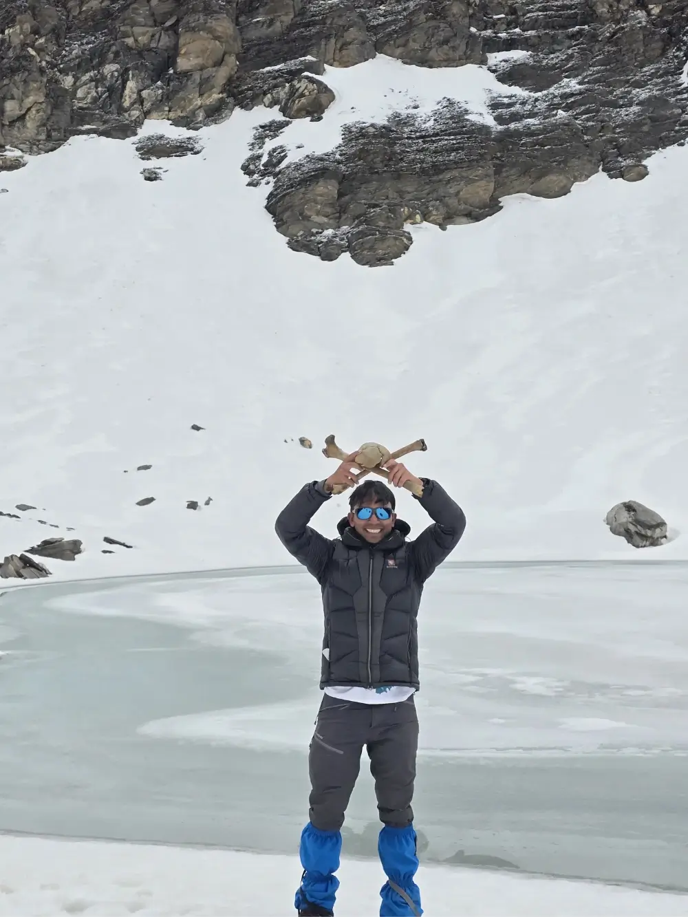 Trekker holding a bone near the mysterious Roopkund Lake