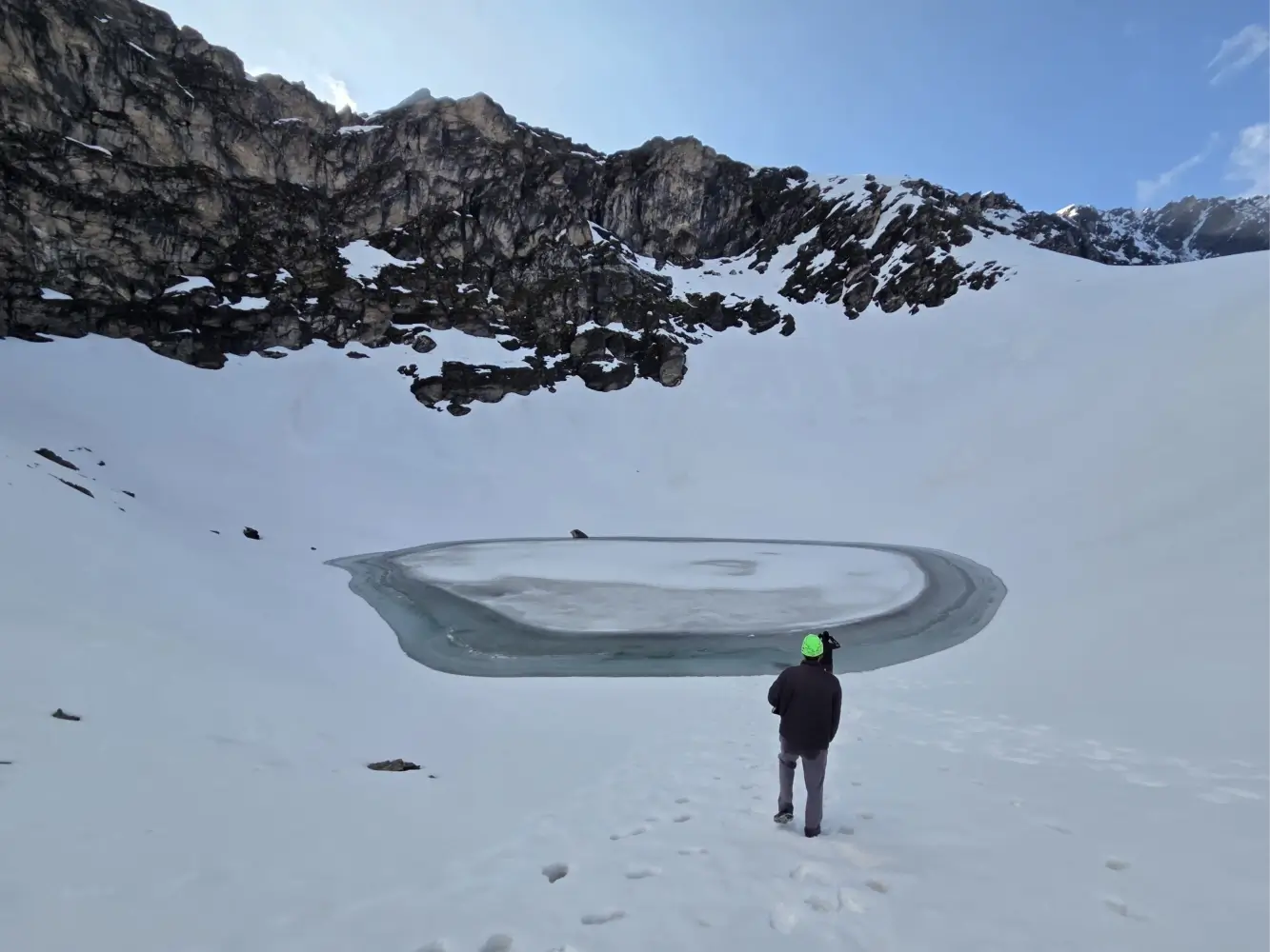 Roopkund Lake surrounded by a snow-covered Himalayan landscape